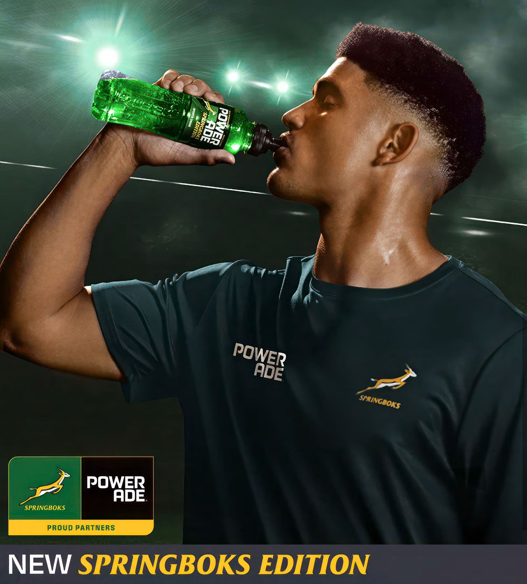 Sweaty athlete in a Springboks shirt drinks green Powerade under bright stadium lights.